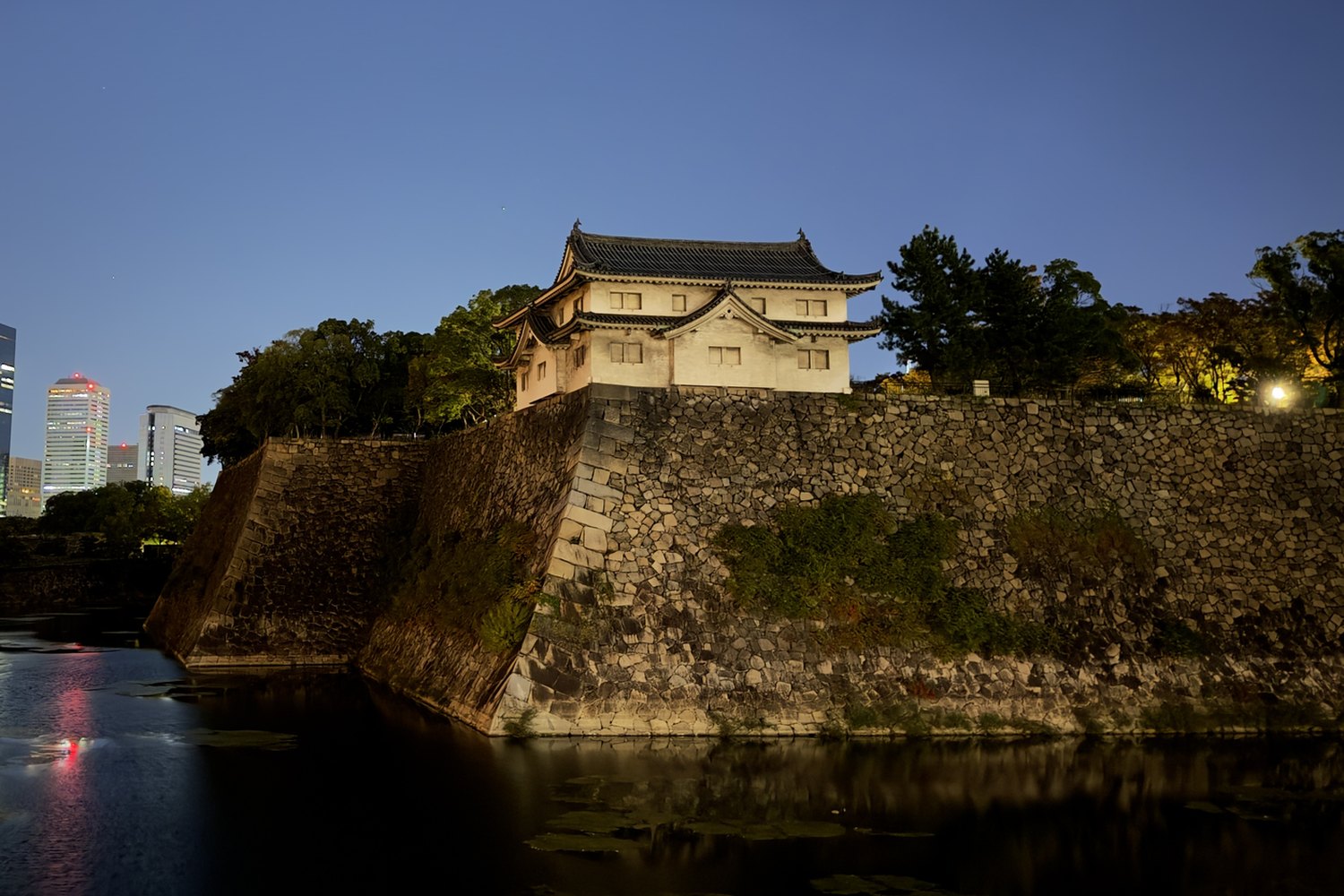 A lit castle keep above a moat at dusk, as the iPhone renders it.